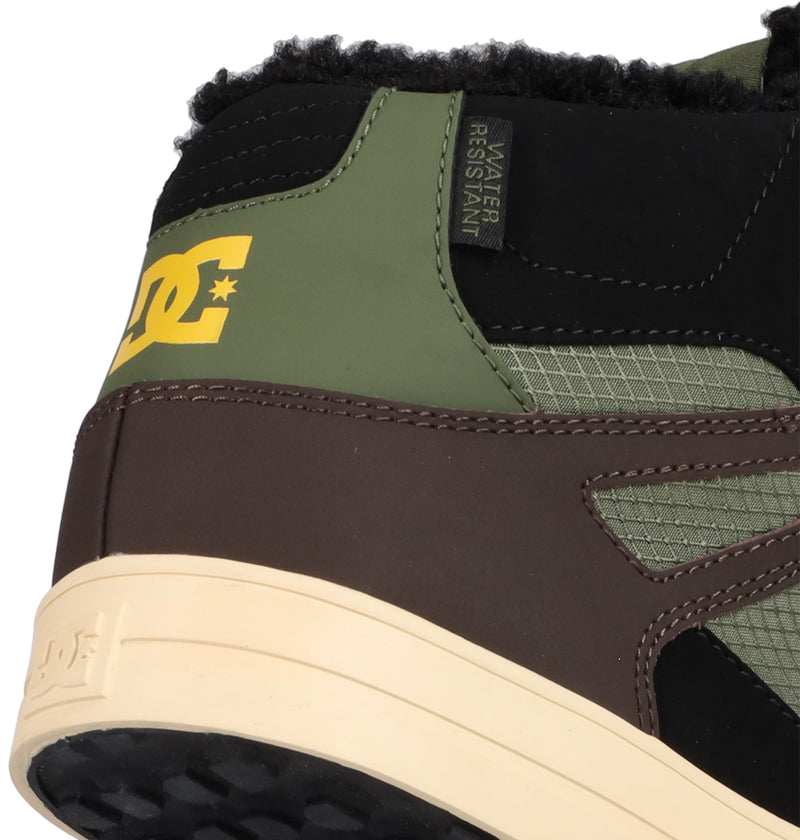 Close-up of the heel of the Men's Pure High Top WC Shoes by DC Shoes, showing brown, green, and black panels, a yellow DC Shoes logo, WATER RESISTANT tag, and a textured off-white sole with visible stitching and tread.