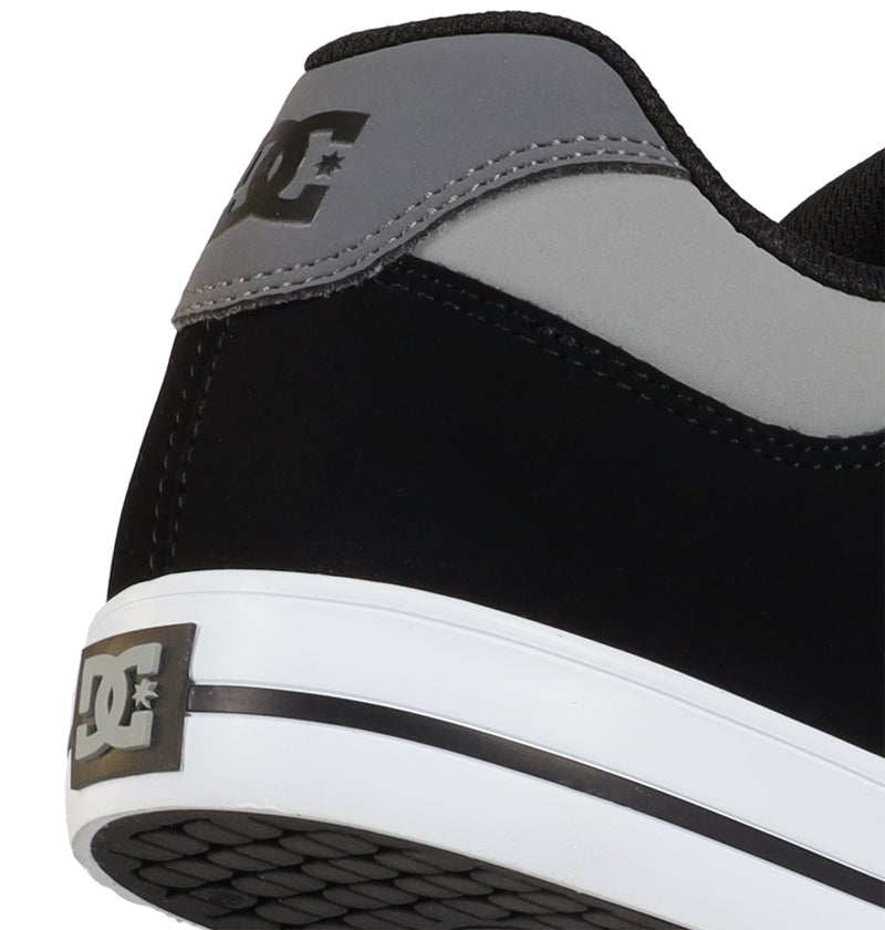 Close-up of the heel of DC Shoes Men's Pure Shoes in black and gray, featuring a white sole with a black stripe and the DC logo on the heel—ideal for anyone wanting versatile footwear.