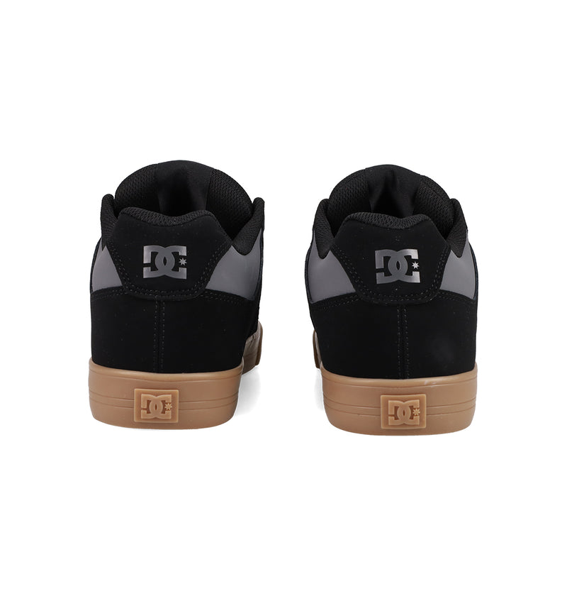 A pair of Men's Pure Shoes by DC Shoes in black and gray with gum soles, viewed from the back. The DC logo appears on the heel tabs and soles, making these shoes a comfortable, versatile addition to any wardrobe.
