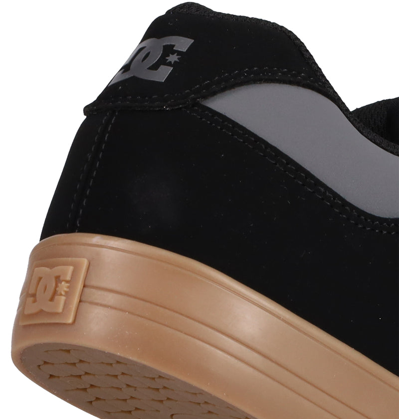Close-up of the heel of DC Shoes Men's Pure Shoes in black and gray, with a tan rubber sole and DC logo on the back and side—these comfortable skate shoes are great for daily wear.