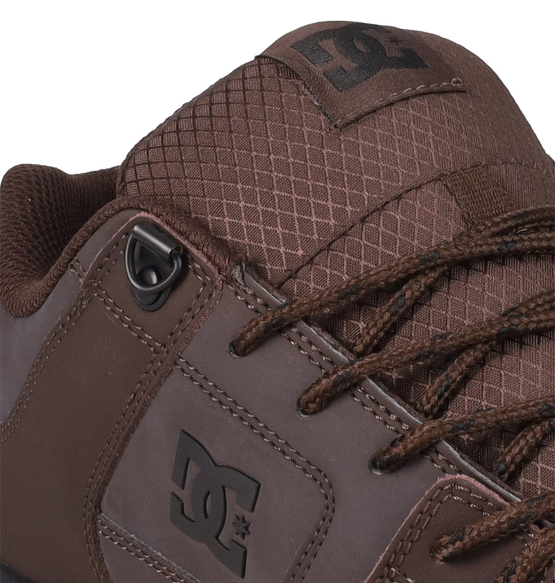 Close-up of the Men's Pure Shoes by DC Shoes, showing textured fabric on the tongue, brown laces, and an embossed DC Shoes logo—ideal for comfortable, versatile style.