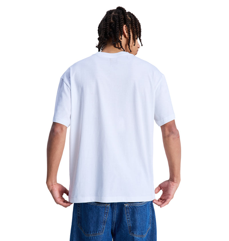 A person with braided hair stands with their back to the camera, wearing a Reebok Queltra Lhss plain white T-shirt and blue jeans against a white background.