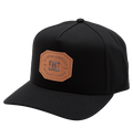 The Men's Reynotts Cap by DC Shoes is a black skate cap with a curved brim, featuring a brown leather front patch debossed with “DC Shoe Company, Est. 1994, Quality Goods.”.