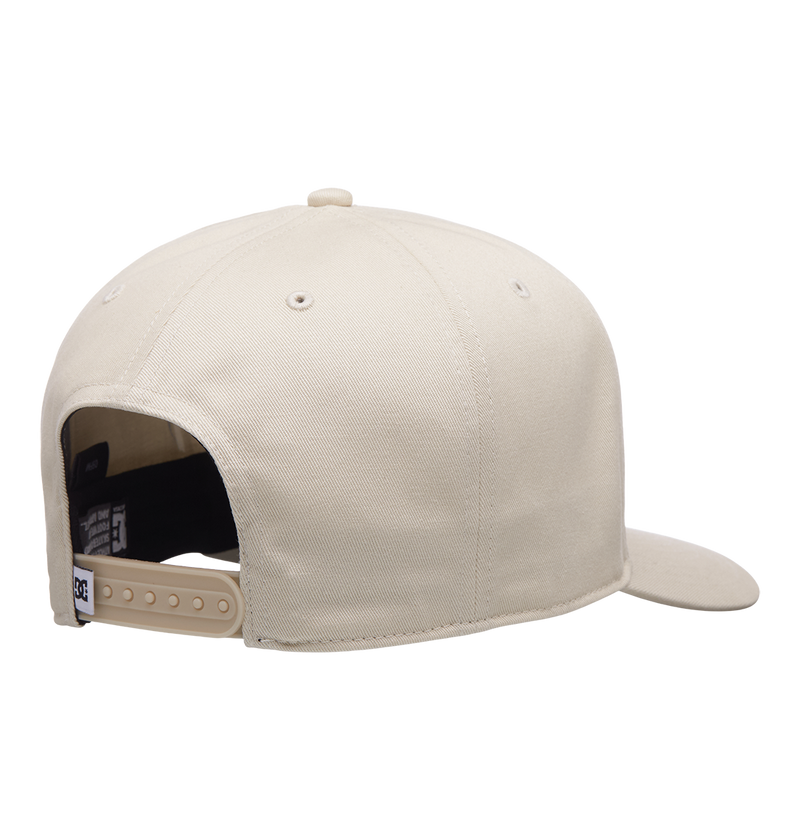 A rear view of the Men's Reynotts Cap by DC Shoes in beige shows DC branding, an adjustable plastic snapback strap, and part of the curved brim against a plain white background.