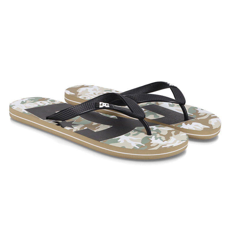 The Men's Spray Graffik Slides by DC Shoes feature black straps and green, beige, and white camo-patterned soles. Shown side by side on a white background, they're perfect to slip on after a skate session.