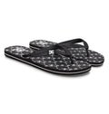 The Men's Spray Graffik Slides by DC Shoes feature black textured straps, black footbeds with white star patterns, and a white logo near the heel—perfect slides to relax in after a skate session.