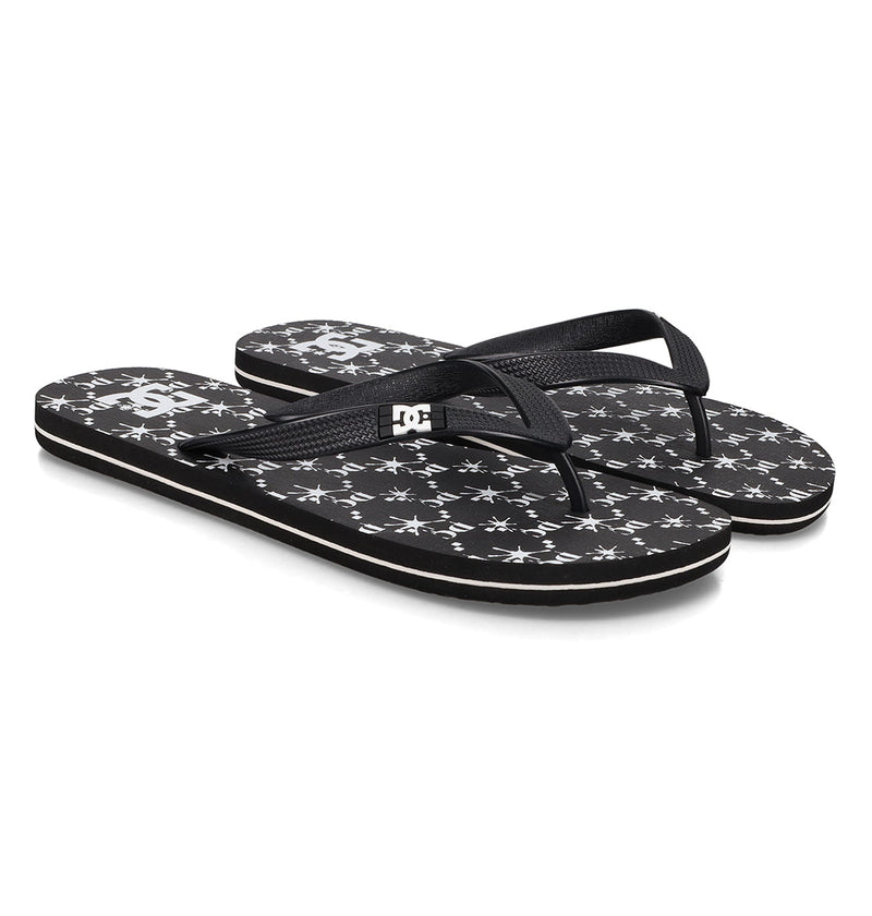 The Men's Spray Graffik Slides by DC Shoes feature black textured straps, black footbeds with white star patterns, and a white logo near the heel—perfect slides to relax in after a skate session.