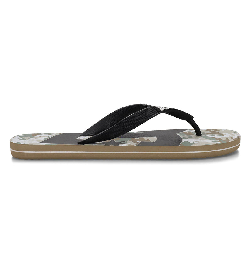 The Men's Spray Graffik Slides by DC Shoes feature a camouflage-patterned flat sole, black straps, and a brown bottom layer, shown in a side profile on a white background.