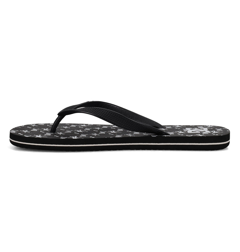 The DC Shoes Men's Spray Graffik Slides are black slip-on sandals with a textured gray and black abstract sole, black thong strap, thin flat profile, and white trim—perfect for any casual skate session.