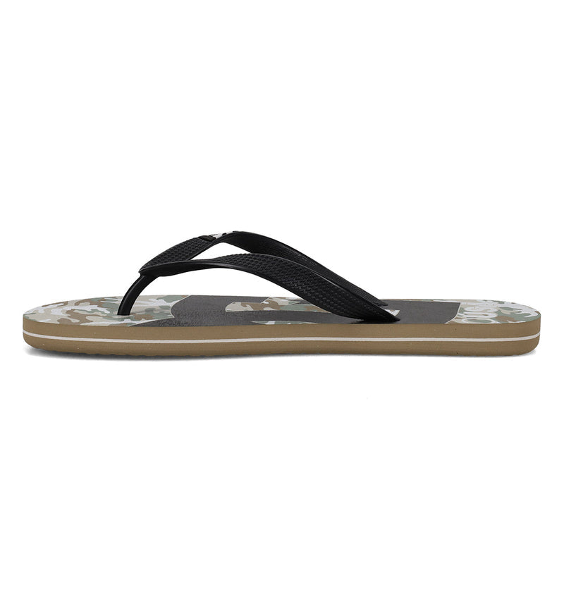 The DC Shoes Men's Spray Graffik Slides feature black textured straps, a camouflage-patterned sole, and a beige rubber bottom. Shown from the side against a white background.