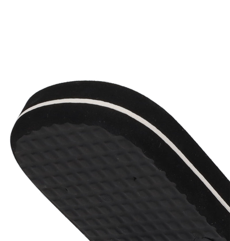 Close-up of the sole of DC Shoes Men's Spray Graffik Slides, a black slip-on sandal with a textured bottom and thin white stripe—ideal for relaxing after a skate session.