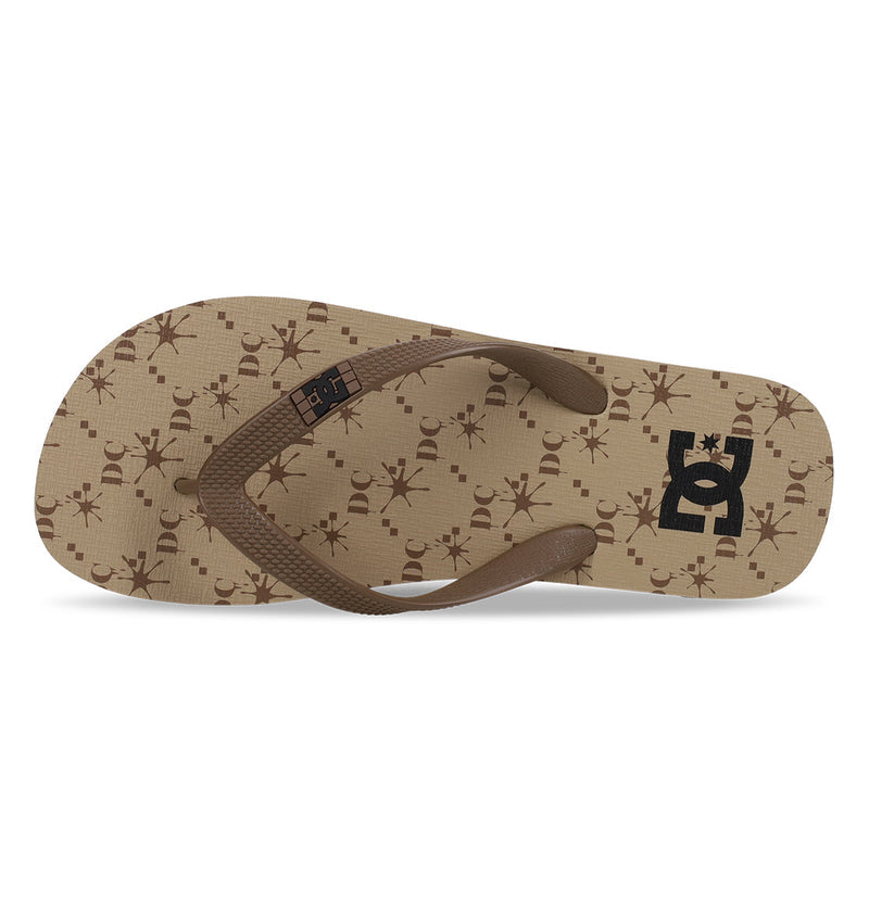 The DC Shoes Men's Spray Graffik Slides feature a brown textured strap, beige sole with brown abstract patterns, and a black DC Shoes logo at the heel—essential slides to relax in after any skate session.