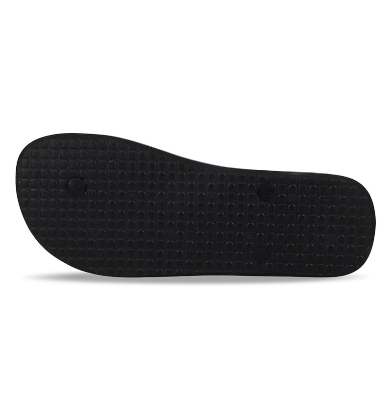The image shows the bottom view of DC Shoes Men's Spray Slides in black, featuring a textured grid-like sole with two small circular indents. The sandal is displayed against a plain white background.