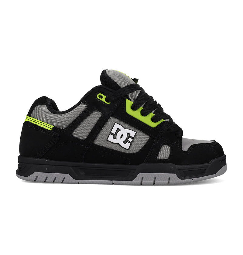 Black sneaker with green accents and a visible brand logo on a white background