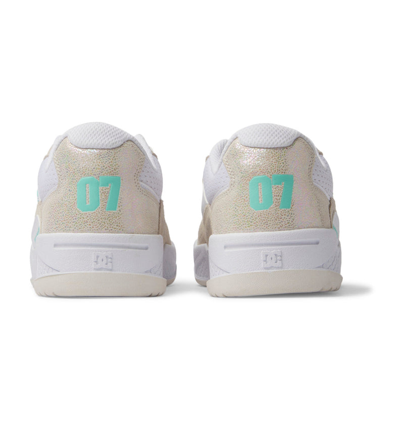 The Women's Construct Shoes by DC Shoes are white sneakers with leather uppers, mesh accents, iridescent details, mint green 07 numbers on the heels, and white soles, shown from the back.