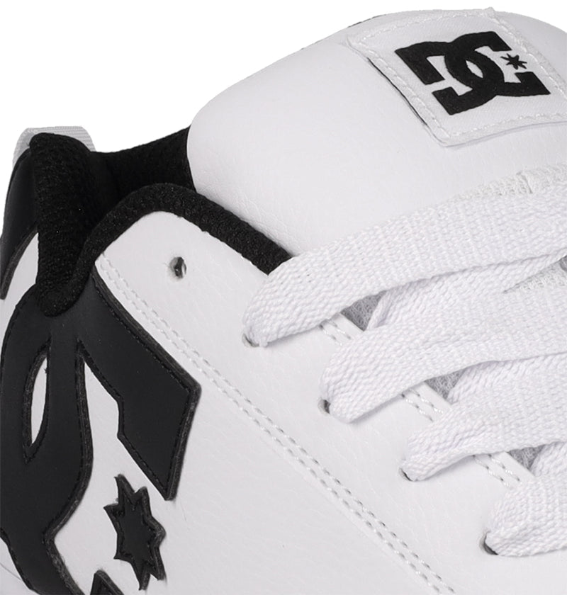 Close-up of the Women's Court Graffik Shoes by DC Shoes: a modern chunky white sneaker with black accents, bold black DC Shoes logos on the side and tongue, and white laces—giving classic '90s style a fresh update.