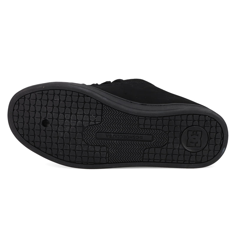 The sole of a black Women's Court Graffik Shoe by DC Shoes features a textured grid pattern for grip, with the DC logo and DCSHOECOUSA embossed in the center.