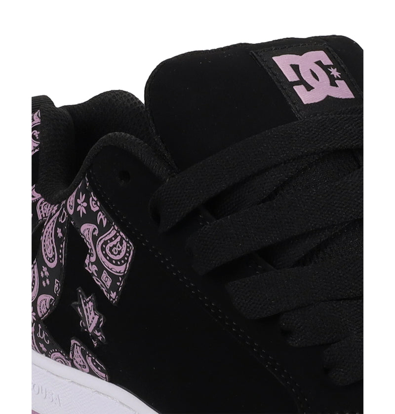 Close-up of a black Women's Court Graffik Shoe by DC Shoes, featuring black laces, pink paisley patterns, and pink DC logos on the tongue and side. A white sole gives these sneakers a bold '90s look.