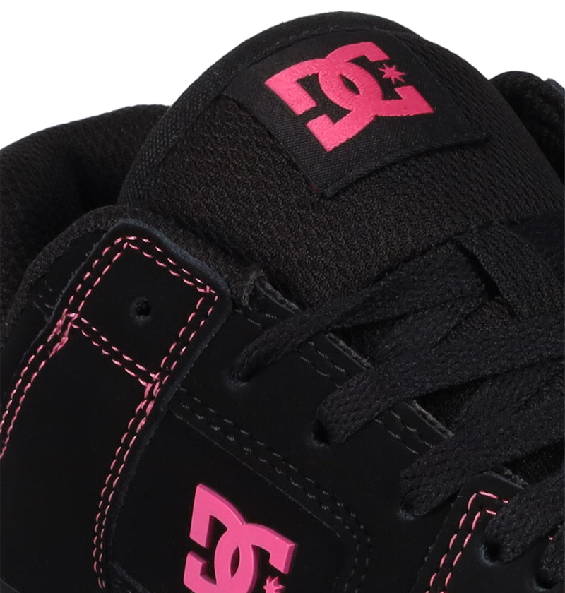 Close-up of a black Women's Manteca 4 Shoe by DC Shoes, showcasing pink logo and stitching accents on the side and tongue, with black laces—a standout choice for women's skate shoes.